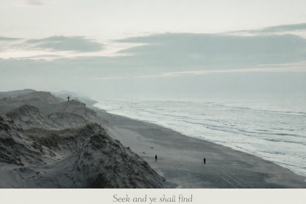 A quiet shoreline with gentle ocean tide and a tiny cross on a cliff, symbolizing seeking Jesus and unfailing love