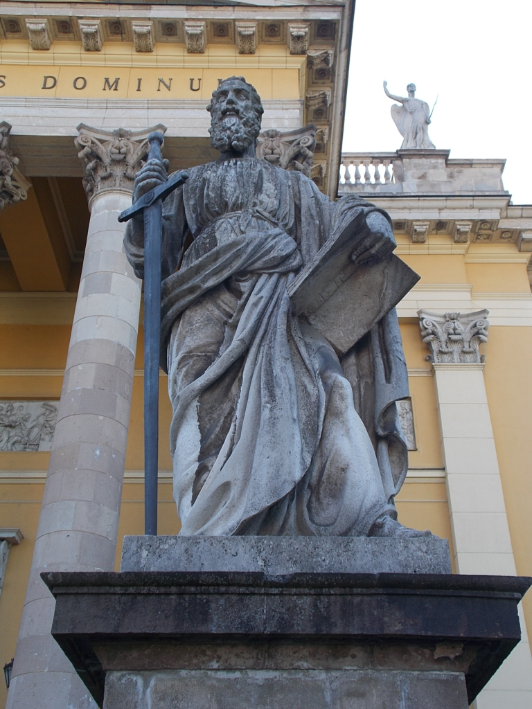 Stone statue of Saint Paul holding a sword and scroll in front of Eger Basilica in Hungary.